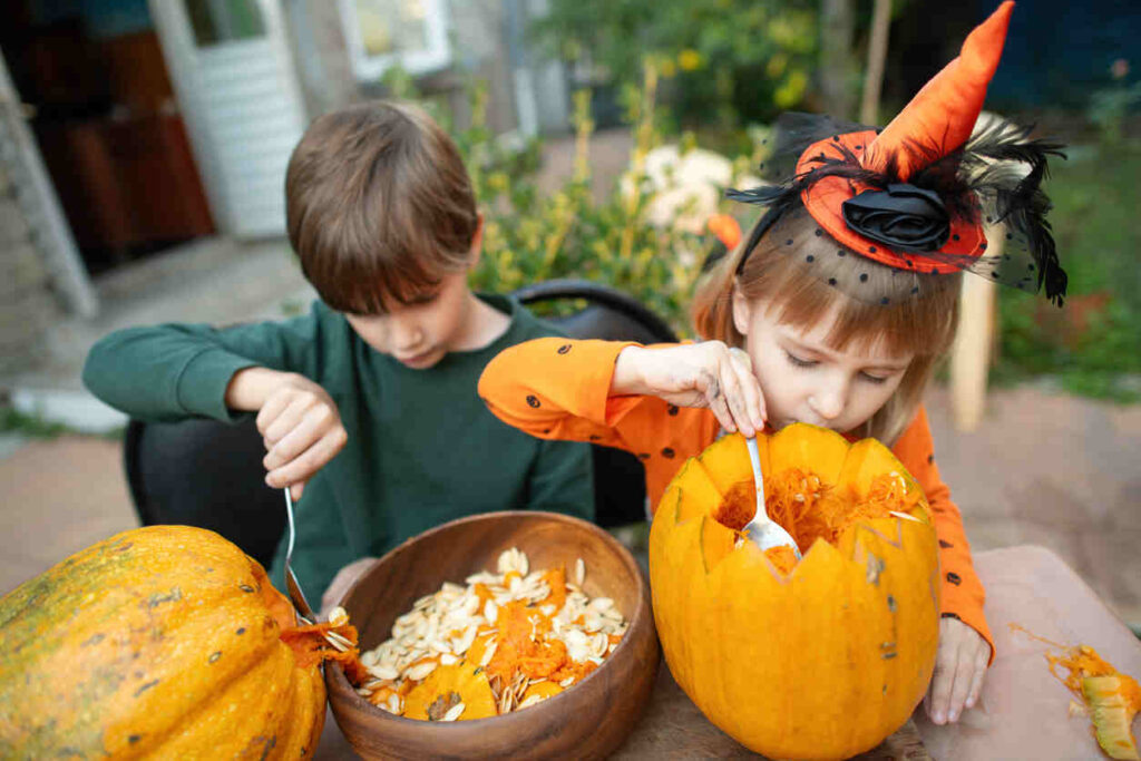 bambini vestiti tema Halloween decorano la zucca