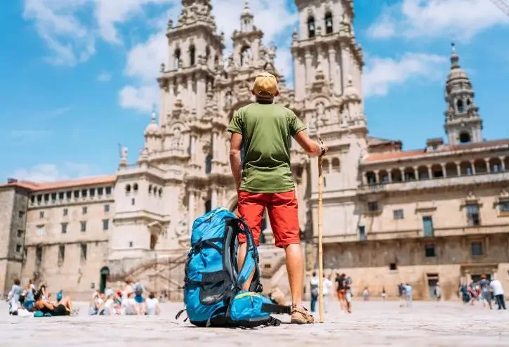 Giovane pellegrino in piedi sulla piazza Obradeiro la piazza principale di Santiago de Compostela