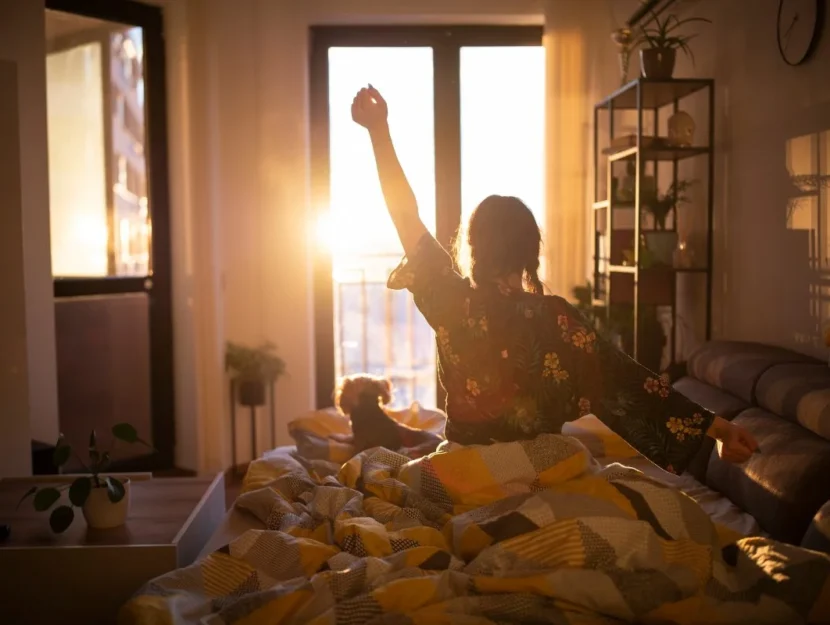 Una ragazza si sveglia con il sole che entra dalla finestra