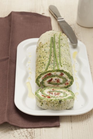 <p><b>Ingredienti </b></p><p> 300 g di spinaci già puliti <br /> 5 uova <br /> 100 g di parmigiano reggiano grattugiato <br /> 250 g di ricotta fresca <br /> 40 g di pomodori semisecchi <br /> 40 g di pinoli <br /> 1 cucchiaino di aceto balsamico <br /> noce moscata <br /> sale e pepe <br /> <br />Cuocete gli spinaci. Lavate gli spinaci, sgocciolateli e metteteli in una padella con la sola acqua rimasta dal lavaggio e un pizzico di sale. Fateli saltare, finché saranno asciutti e quasi appassiti. Lasciateli raffreddare, poi tritateli finemente. </p><p>Montate gli albumi. Sgusciate le uova, separando i tuorli dagli albumi. Sbattete i tuorli con 70 g di parmigiano reggiano, l'aceto, una macinata di pepe, un pizzico di sale e uno di noce moscata. Unite gli spinaci, quindi gli albumi montati a neve fermissima con un pizzico di sale. Mescolate il composto sollevandolo dal basso verso l'alto per non smontare gli albumi. </p><p>Infornate il rotolo. Foderate con un foglio di carta da forno una teglia a bordi bassi di 23x32 cm, versatevi il composto preparato e livellatelo con una spatola, in modo da ottenere un rettangolo di spessore uniforme. Cuocetelo in forno già caldo a 180° per circa 20 minuti o finché risulterà rappreso, ma ancora morbido. </p><p>Completate. Cospargete un altro foglio di carta da forno con il parmigiano reggiano rimasto, rovesciatevi sopra il composto di spinaci tolto dal forno, copritelo con un secondo foglio di carta e lasciatelo raffreddare. Quindi eliminate il foglio di carta posto sulla superficie, spalmate il rettangolo con la ricotta prima lavorata a crema, cospargete con i pomodori tagliuzzati e i pinoli tritati grossolanamente. Arrotolate il tutto su se stesso, aiutandovi con il foglio di carta. Trasferite il rotolo in un piatto da portata e servitelo tagliato a fette. </p>