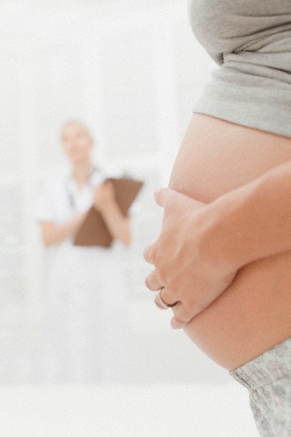 Close up of pregnant woman holding belly --- Image by © Hybrid Images/cultura/Corbis