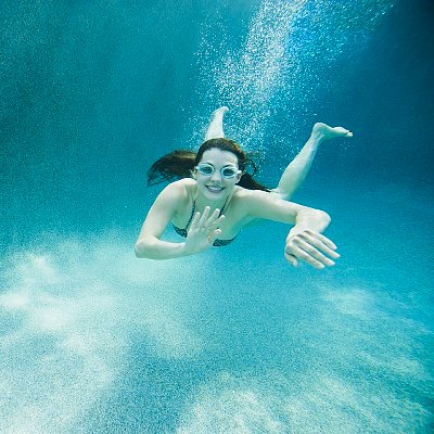 St. George, Utah, USA --- USA, Utah, St. George, Young attractive woman diving in swimming pool --- Image by © Erik Isakson/Tetra Images/Corbis