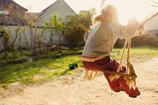 Girl swinging --- Image by © Matthias Ritzmann/Corbis