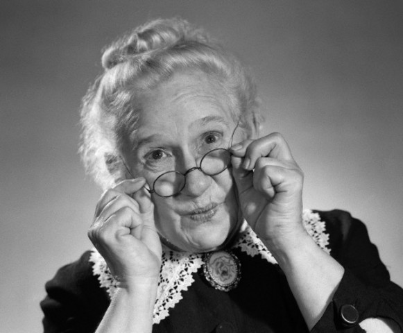 01 Aug 1956 --- 1950s PORTRAIT OF SMILING OLD LADY HOLDING HER ANTIQUE WIRE FRAME GLASSES --- Image by © H. ARMSTRONG ROBERTS/Corbis