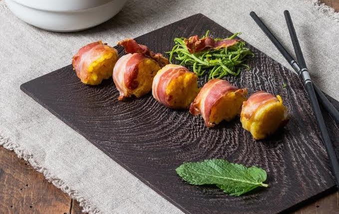 <p><b>Ingredienti</b></p><p>Riso avanzato e zafferano</p><p>Parmigiano</p><p>Bacon</p><p>Menta</p><p>Lime</p><p>Un pratica soluzione per un finger food d’effetto: scaldare il riso avanzato con lo zafferano insieme al parmigiano e la buccia di lime, quindi dei roll delle dimensioni del sushi.</p><p>Rosolare in una padella il bacon calcolando 5 fette per ogni roll.</p><p>Scottare nella stessa padella della salsiccia i sushi di riso.</p><p>Decorare i roll con il bacon e foglie di menta.</p>
