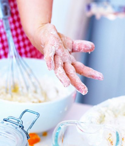 <p><b>Cucinare con i bambini</b>, un'attività semplice che racchiude un immenso patrimonio! Tanto che la questione è stata anche oggetto di uno studio scientifico: secondo una recente ricerca canadese, infatti, coinvolgere i propri <b>figli</b> nella <a href="https://www.donnamoderna.com/tag/ricette-con-bambini" rel="nofollow" target="_self"><b>preparazione dei pasti</b></a> li aiuta ad avere una migliore <a href="https://www.donnamoderna.com/tag/alimentazione-bambini" target="_self"><b>alimentazione</b></a> (anche da adulti). Inoltre i bambini abituati a cucinare con i genitori hanno anche una minore incidenza di <b>sovrappeso</b> o obesità.</p><p>Una ricerca che conferma quello che ogni <b>mamma</b> sa e sperimenta ogni giorno: <b>cucinare</b> con i propri figli è un'attività importante per molti aspetti. È d'aiuto per i <b>bambini inappetenti</b>, che vengono stimolati almeno ad assaggiare cose nuove e diverse. E poi gustare un piatto preparato con le proprie manine ha tutto un altro sapore! Inoltre in cucina si impara ad avere <b>pazienza</b> aspettando che un <b>cibo</b> si cucini o un impasto prenda la giusta consistenza. Un po' come nel <a href="https://www.donnamoderna.com/mamme/bambini-4-12-anni/come-fare-giardinaggio-bambini" target="_self">giardinaggio</a>: piantare un seme, curare una piantina aspettando che cresca allena i bambini ad aspettare, una qualità che da piccoli è quasi inesistente!</p><p>Poi c'è la gioia di fare qualcosa di utile, <i>"da grande"</i>, che fa sentire sempre molto orgogliosi i bambini. La <b>felicità</b> di assaggiare qualcosa che hanno creato loro stessi (anche se in parte). Insomma, la <b>preparazione dei pasti</b> non rimane un'incombenza che separa i <b>genitori dai figli</b>... in un momento di noia o nervosismo prova a chiedere al tuo piccolo di aiutarti a lavare la verdura o condire l'insalata. Immediatamente la tensione si scioglierà e vi ritroverete di nuovo uniti in un momento di <a href="https://www.donnamoderna.com/mamme/posso-aiutarti-mamma/tempo-figli-qualita-quantita" target="_self"><b>qualità</b></a> da passare insieme.</p><p> Ma quando si può iniziare a coinvolgere i bambini in cucina? Già dai <b>18 mesi</b> (o anche prima) con la manipolazione dei cibi e i travasi. E poi via via con gli impasti e la preparazione degli ingredienti. Sempre sotto la sorveglianza di un adulto perché, bisogna ricordarlo, la <b>cucina</b> è anche una fonte di pericoli per i bimbi.<br />Vediamo <b>età per età</b> come ci possono aiutare i nostri <b>piccoli cuochi</b>!</p>