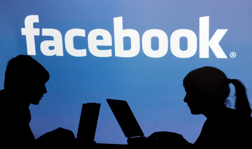 26 Apr 2010, Straubing, Germany --- FILE - ILLUSTRATION - An archive picture dated 26 April 2010 shows the shadows of two persons with their laptops in front of the Facebook logo in Straubing, Germany. According to media reports, Facebook plans its initial public offering in 2012. Photo: Armin Weigel --- Image by © Armin Weigel/dpa/Corbis