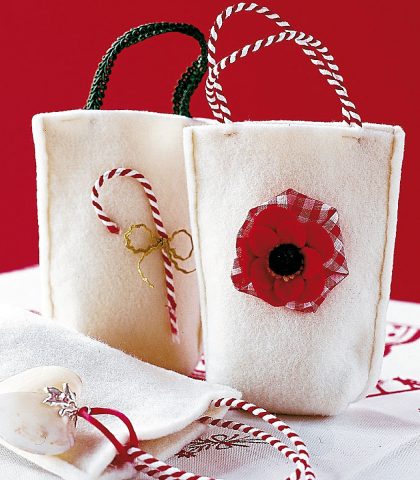 <p><b>Il regalo è dentro o fuori?</b><br>Quest’anno niente carta e nastri. Per impacchettare prepara invece delle shopping bag: belle, facili e utili. Ritaglia nel panno bianco due rettangoli di circa cm 25x15; con le forbici arrotonda gli angoli in basso e dai una forma leggermente svasata, poi cuci tutto attorno. Con due cordoncini realizza i manici; infine decora con un fiore di stoffa, un fiocco o un cuore.</p><p><b>Come si fanno</b><br> Le borsine misurano circa cm 25x15, ma puoi realizzarle anche più piccole o più grandi, secondo il regalo che devono contenere. Mentre al posto del panno puoi utilizzare anche del pile bianco oppure rosso.<br> <b>1. </b>Cuci due rettangoli su tre lati, a cm 0,5 dal margine.<br> <b>2.</b> Due cordoncini lunghi cm 30 formano i manici.<br><b>3.</b> Applica le decorazioni. Per esempio, sovrapponi tre corolle di grandezza decrescente e fissale al centro con un bottone.</p>