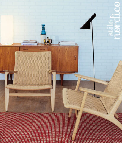 <p>Perfetto <b>stile nordico</b> per questo soggiorno con le sedute basse, tipiche dell’area scandinava: le poltrone progettate da Hans Wegner, designer danese. Fa da sfondo l'<b>azzurro tenue</b> della parete.</p>