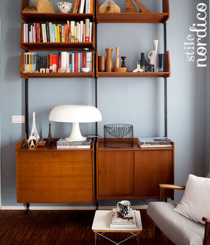 <p>Se ti piace la linearità e la purezza dello <b>stile nordico</b> devi abbinare<b> tinte chiare o pastello</b> alle pareti. Come in questo soggiorno dove un tenue azzurro polvere fa da sfondo alla libreria di gusto nordico degli anni ’60.</p>