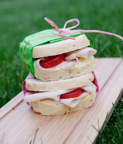 <p>Una <b>merenda</b> per chi ama il salato e perfetta per una <b>gita all'aperto</b>: i <b>sandwich farciti </b>con prosciutto cotto, pomodori e maionese! Puoi variare la farcitura in base ai gusti della tua <b>famiglia</b>: feta e bresaola dal gusto deciso o caprino e zucchine grigliate per una versione vegetariana e delicata.</p><p> Vuoi provare a fare il pane per i sandwich in casa? Un'esperienza importante da condividere con i <b>bambini</b>! Ecco la <b>ricetta</b>: <br /> sbriciola 25 g di lievito di birra in una ciotola con 1/2 cucchiaino di zucchero, diluisci con 2 dl di latte e fai riposare per 15 minuti. <br />Mescola 300 g di farina 0 con 200 g di farina di riso e 1 pizzico di sale. Unisci 1 uovo, 40 g di burro fuso, 100 g di grana padano grattugiato e il composto di latte e lievito. Lavora fino a ottenere una pasta di media consistenza. Coprila e lascia lievitare per 1 ora. Quindi forma un rotolo di pasta, mettilo in stampo da plum cake di 30 cm di lunghezza imburrato, spennella di olio e cospargi con semi di sesamo. Fai lievitare per 50 minuti, poi cuoci in forno caldo a 200° per 40 minuti.</p>