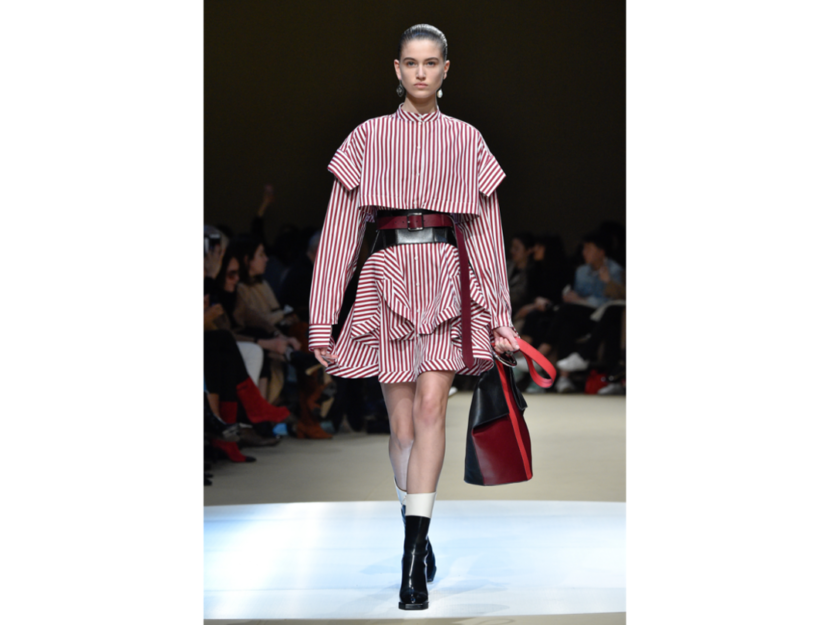 <p>La modella indossa un mini abito svolazzante a righe binche e rosse di Alexander McQueen</p>