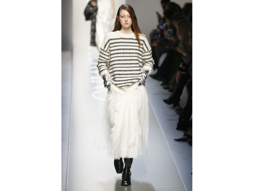 <p>La modella sfoggia un pullover a righe bianche e nere con una gonna lunga in tulle</p>
