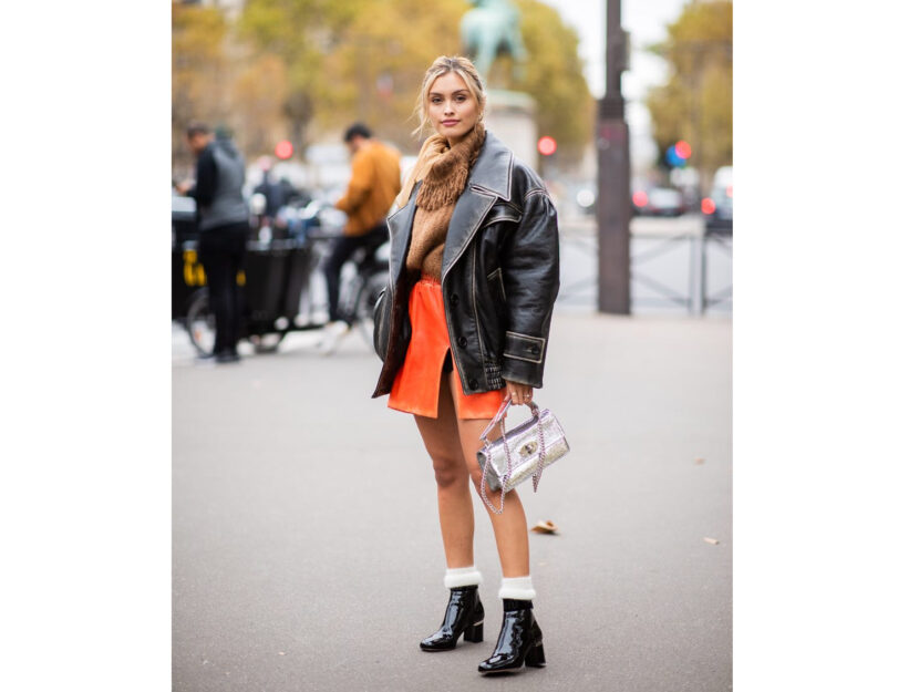 <p>La modella sfoggia una gonna corta di pelle arancione per un look super glam</p>