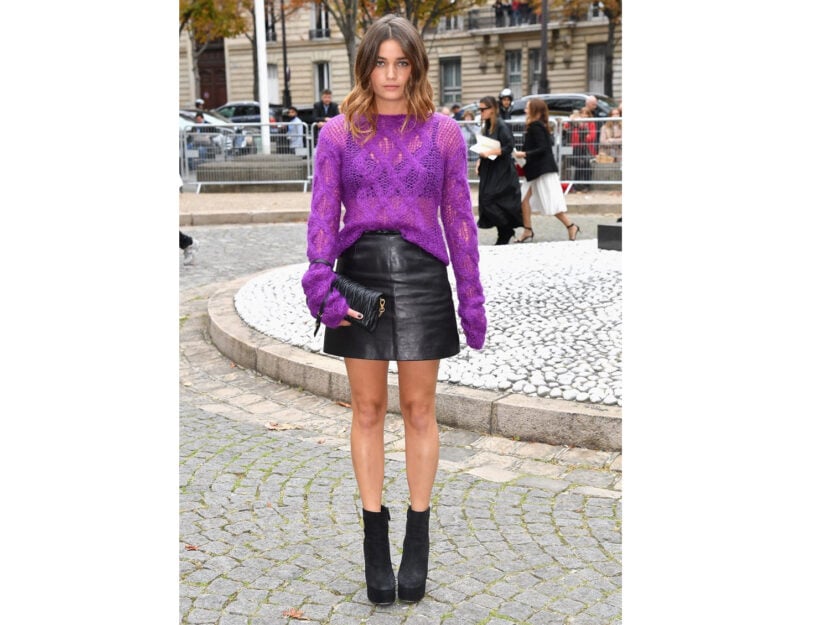 <p>La gonna di pelle corta nera si abbina al pullover lavorato a maglia viola</p>