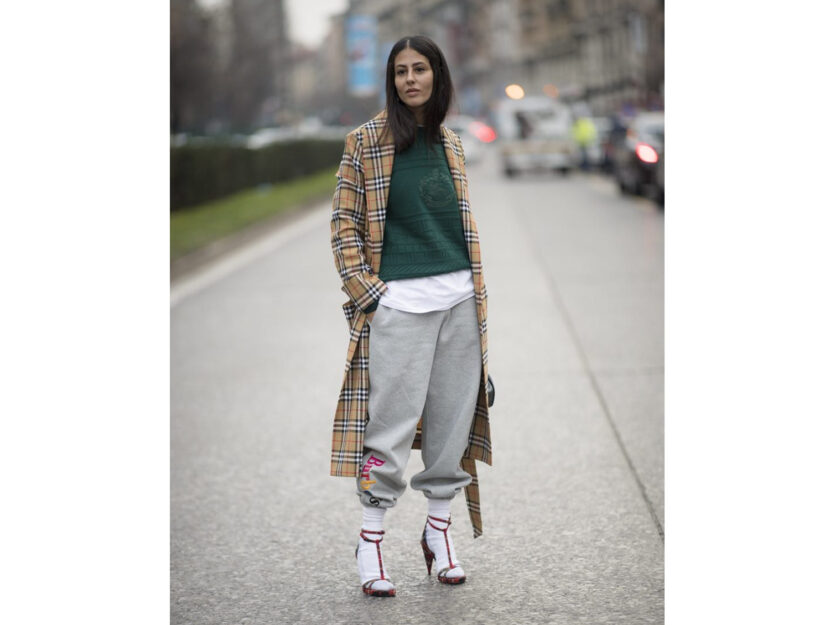 <p>Il cappotto lungo a quadretti si porta con un outfit sporty</p>