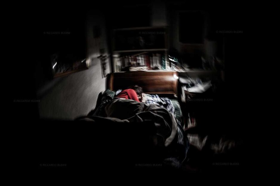 <p>Questa foto ritrae Maria Grazia Budini, sorella del fotografo autore dello scatto, Riccardo. Maria Grazia soffre di emicrania fin dall'adolescenza, come la madre. Entrambe hanno crisi di dolore che scatenano anche attacchi di panico. Con questa foto (e altre che fanno parte del progetto "Vivere con l'emicrania") Budini ha voluto testimoniare come il dolore cronico condizioni la vita di chi ne soffre. <br data-mce-bogus="1"></p>