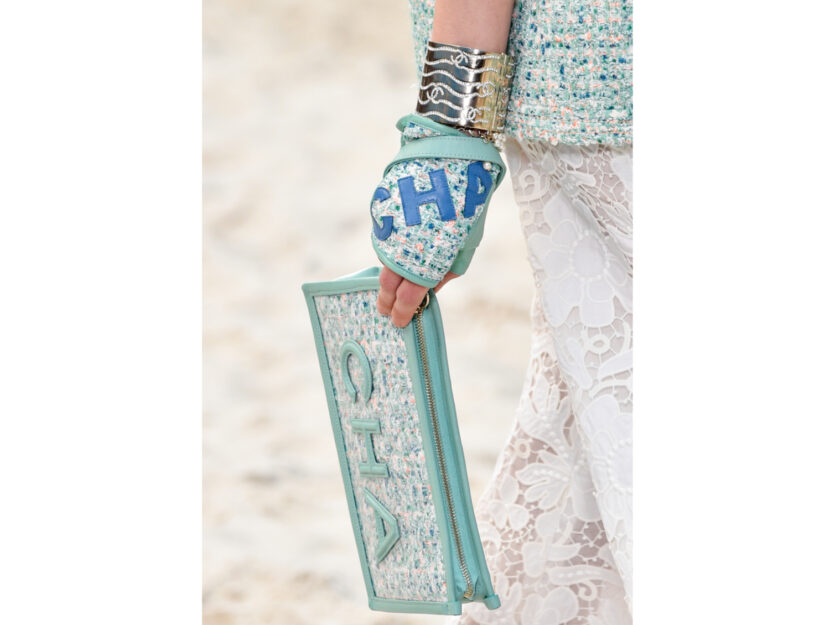 <p>Clutch verde menta in tweed con logo di Chanel</p>